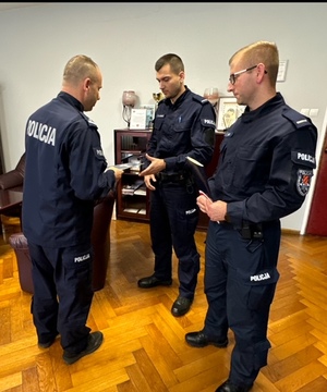 komendant Powiatowy Policji w Kłodzku wręcza podziękowania i gratuluje policjantowi . Foto w pomieszczeniu służbowym policji