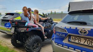 dzieci siedzą na quadzie , widać fragment radiowozów