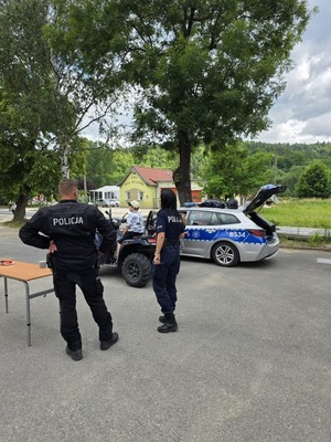 policjantka i policjant stoją w pobliżu radiowozu
