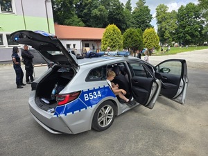 otwarty radiowóz zaparkowany na placu w pobliżu sa dzieci