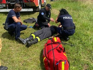 Policjanci wraz ze strażakiem podczas ćwiczenia udzielania pomocy