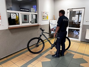 Policjant stoi przy odzyskanym rowerze
