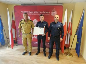 obok siebie stoi komendant straży policjant i komendant policji