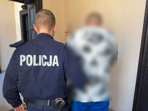 policjant prowadzi zatrzymanego mężczyznę