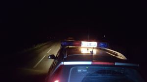 radiowóz nocą zaparkowany z włączonym podświetleniem na dachu napis-policja