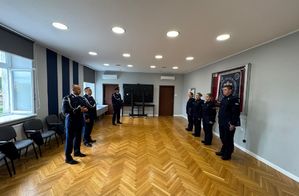 policjanci stoja naprzeciw przełożonych -oficerów Policji w sali sztabowej