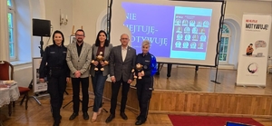 dwie policjantki stoją  z grupa osób w pomieszczeniu konferencyjnym