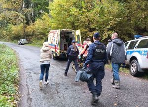 służby  pogotowie i ambulans oraz ratownicy przy noszach oraz policjanci na zdjęciu