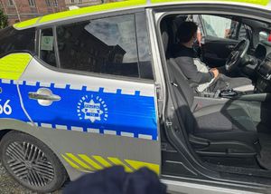 w radiowozie policyjnym za kierownic siedzi uczeń-chłopiec