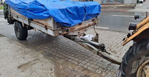 część rozrzutnika zaparkowany i widać część ciągnika  do którego jest przyczepiony rozrzutnik