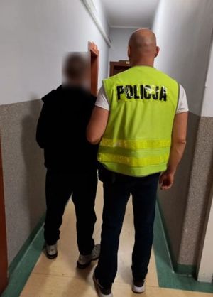 policjant w pomieszczeniu służbowym prowadzi zatrzymanego chłopca