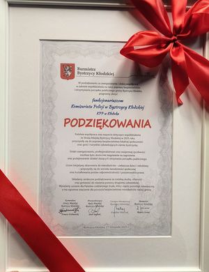 podziekowanie dla policjantów z Bystrzycy Kłodzkiej - Funkcjonariusze z Bystrzycy Kłodzkiej otrzymali od pani Renaty Surmy Burmistrz Bystrzycy Kłodzkiej, podziękowania za zaangażowanie oraz wzorową współpracę w 2025 roku na rzecz poprawy bezpieczeństwa mieszkańców gminy oraz osób odwiedzających region.
Podziękowanie wręczone było 27 listopada br. Podkreśla ono wkład policjantów w szybkie i skuteczne reagowania na zagrożenia, podejmowanie działań ukierunkowanych na utrzymanie porządku publicznego, a także liczne inicjatywy edukacyjne skierowane do dzieci, młodzieży i dorosłych. Szczególny akcent położono na wspólne działania z samorządem w obszarze profilaktyki, budowania świadomości społecznej oraz wzmacniania postaw odpowiedzialności i poszanowania prawa.
W treści podziękowania Burmistrz wyraziła uznanie dla profesjonalizmu, dyspozycyjności i gotowości policjantów do niesienia pomocy drugiemu człowiekowi, podkreślając ich codzienny trud, często pozostający niewidoczny, a mający ogromne znaczenie dla poczucia bezpieczeństwa mieszkańców gminy.