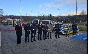 grupa ludzi stoi przy  szarfie