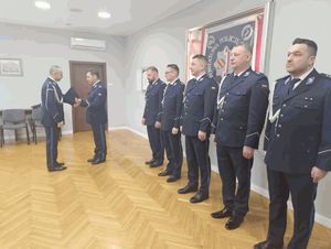 policjanci w sali sztabowej odbierają akty mianowania na stanowiska służbowe-uścisk reki