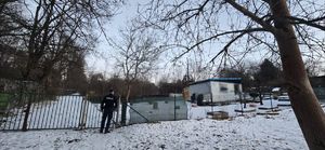 policjanci ida w kierunku zabudowania dookoła lezy śnieg