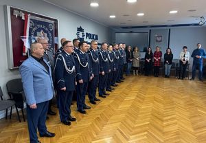 policjanci i pracownicy cywilni  stoją obok siebie w sali sztabowej policji