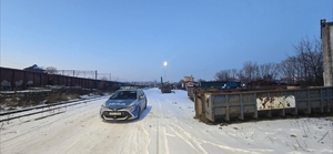 radiowóz zaparkowany na śniegu , widać budynek