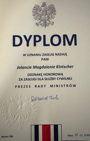 Dyplom dla Jolanty Kintschner , a na górze orzeł na dole flaga służby cywilnej -paski biało granatowo czerwone