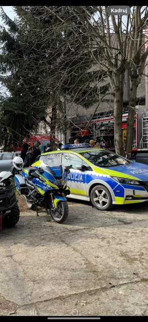 pojazdy służbowe zaparkowane pzry budynku szkoły