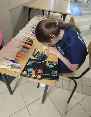 dziewczynka siedzi przy stoliku i rysuje