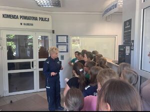 dzieci z policjantka w punkcie recepcyjnym  Komendy Powiatowej Policji w Kłodzku