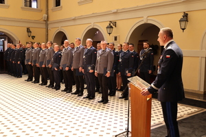 przy mównicy stoi i przemawia Pan Komendant Wojewódzki Policji we Wrocławiu - policjant , widać policjantów  którzy stają w sali zamkowej