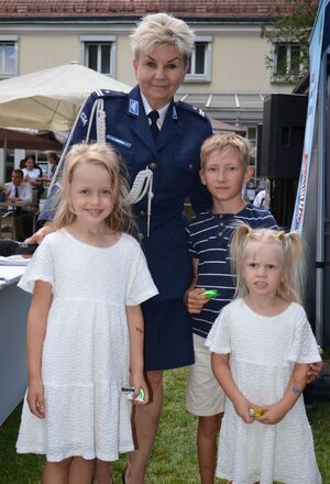policjantka stoi z trójka dzieci