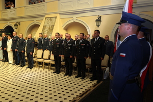 poczet sztandarowy oraz policjanci i policjantki stoją w sali zamkowej