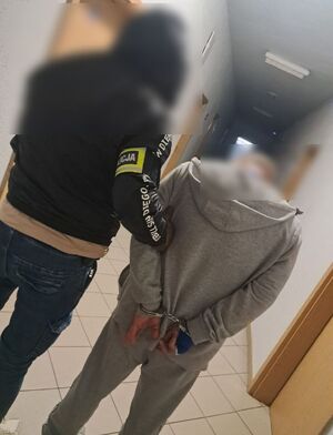 policjant prowadzi zatrzymanego mężczyznę