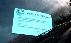 Szyba samochodowa na której pod wycieraczką do szyb znajduje się papierowa ulotka. Na ulotce znajduje się w lewym górnym rogu logo policji powiatu kłodzkiego z napisem Policja Kłodzko. Na ulotce poniżej znajduje się tekst:
Policja ostrzega z trzema wykrzyknikami. Kierowco nie zostawiaj w samochodzie w widocznym miejscu żadnych wartościowych przedmiotów, aparatu fotograficznego, radia, laptopa, torebek i innych gdyż może to zachęcić złodzieja do przestępstwa. W trosce o Twoje mienie Policja.