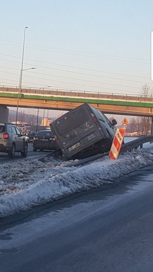 samochód znajduje sie pomiędzy dwoma pasami jedni na pasie zieleni. Samochód jest pochylony, wjechał pokonując barierę