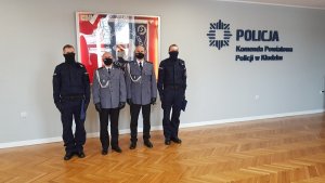 czterech dwóch policjantów stoi w sali sztabowej   w tle widać w gablocie sztandar policji powiatu kłodzkiego