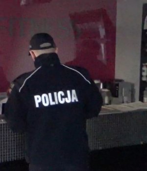 Policjant stoi przy blacie w siłowni.