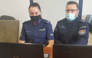 policjantka i policjant siedzą przed komputerami i prowadzą spotkanie online w sali sztabowej Kłodzkiej Komendy Policji