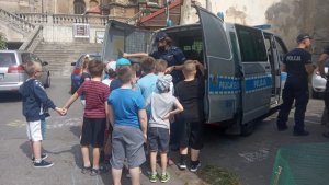 umundurowana policjanta za radiowozem z uczniami